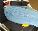 Photo of pressure-sensing pad (yellow) on wheelchair seat and 3-axis accelerometer (red) on simulated SCI patient during "lean to left" weight-relief activity.