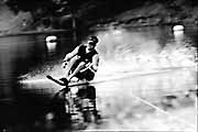 A waterskier glides across the water with adaptive water ski.