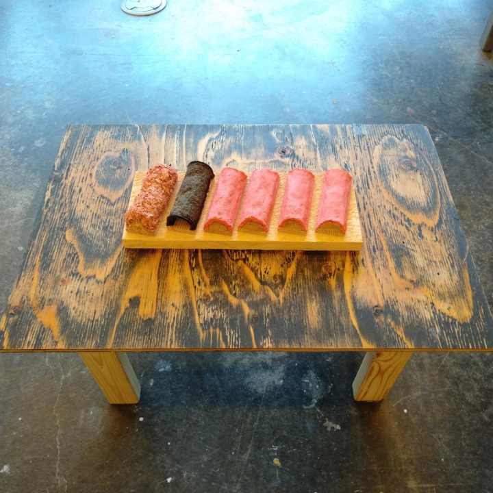 <i>California Cake</i>. A sculpture of six pieces of kamaboko on a low table.