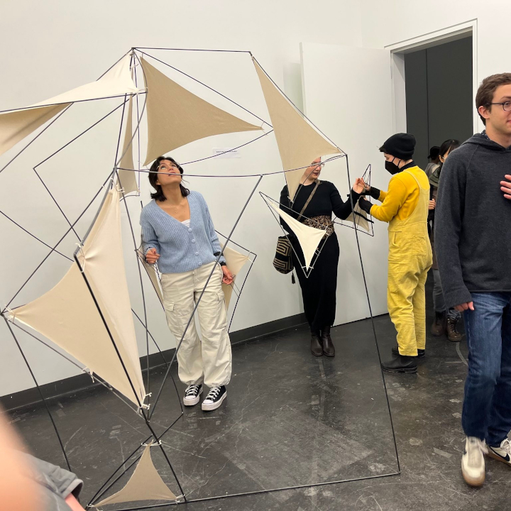 <i>Equip and Merge</i>. A photo of audience members engaging with the sculpture at an exhibition.