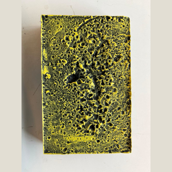 <i>Untitled</i>. A relief sculpture created by splashing water onto setting plaster, painted yellow.